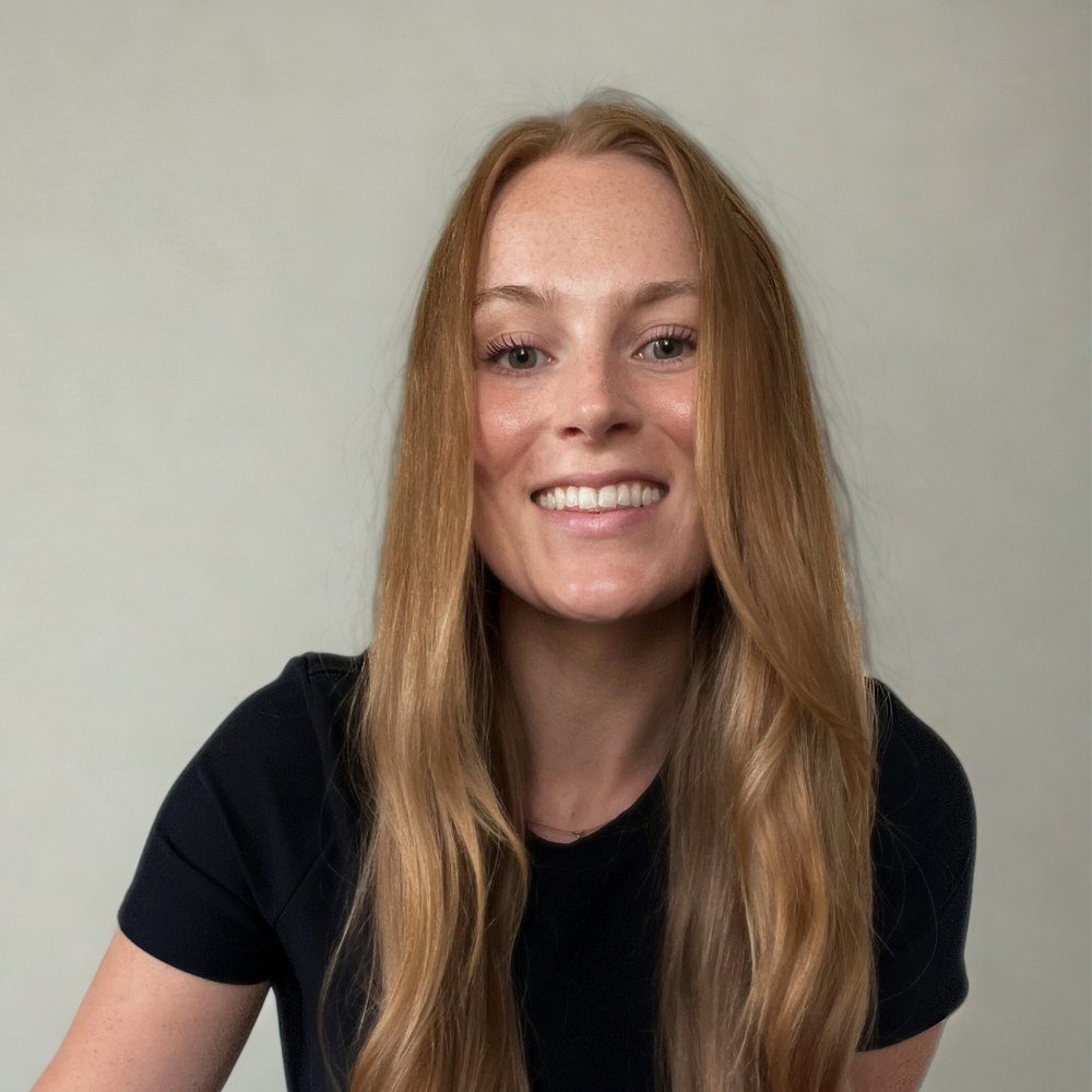 Amanda Williams, Creative Director of Currentform Design, smiling in a black t-shirt against a light gray wall