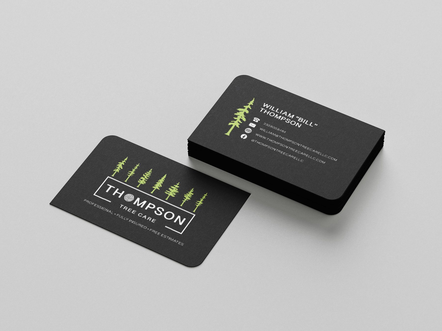 Thompson Tree Care business cards in black with a row of green pines and the boxed wordmark